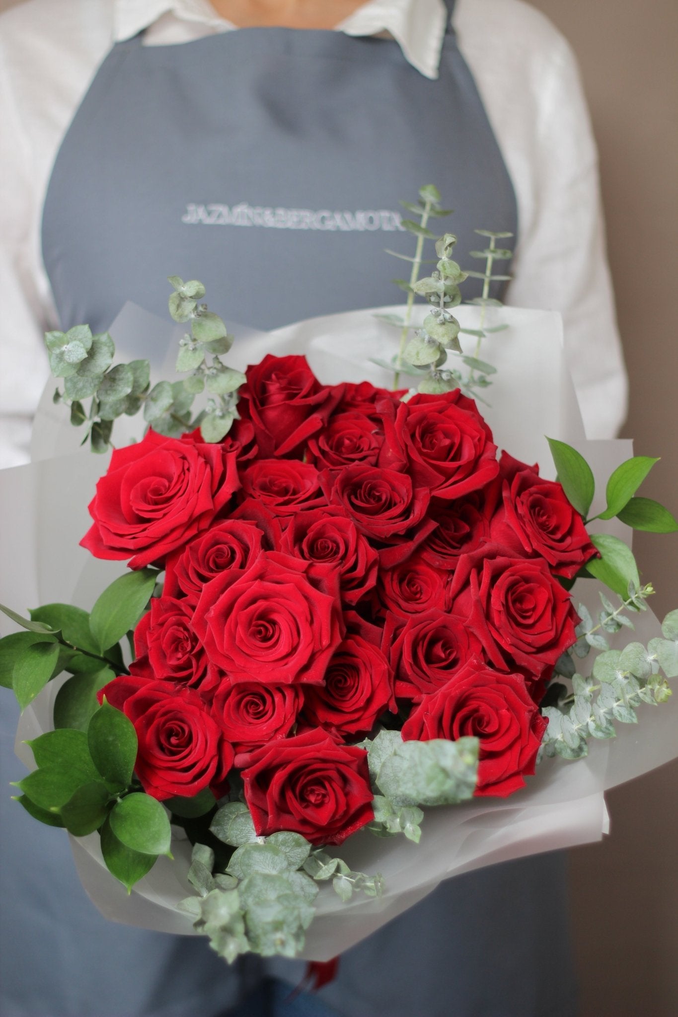 RAMO 24 ROSAS ROJAS CON RUSCUS Y ECUALIPTO - JAZMÍN Y BERGAMOTA